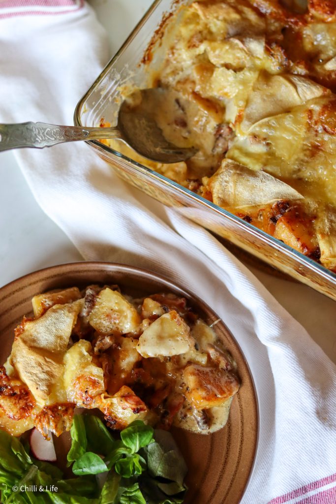 tartiflette on a plate with green salad